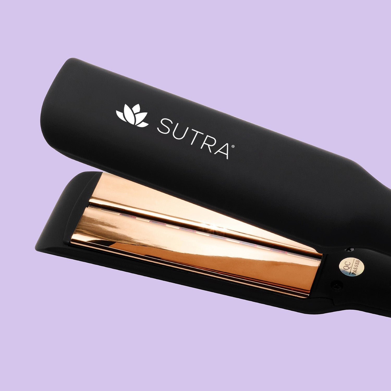 a close-up image of a black flat iron, the gold color plate measuring one and a half inches, gold color details, and the white sutra logo